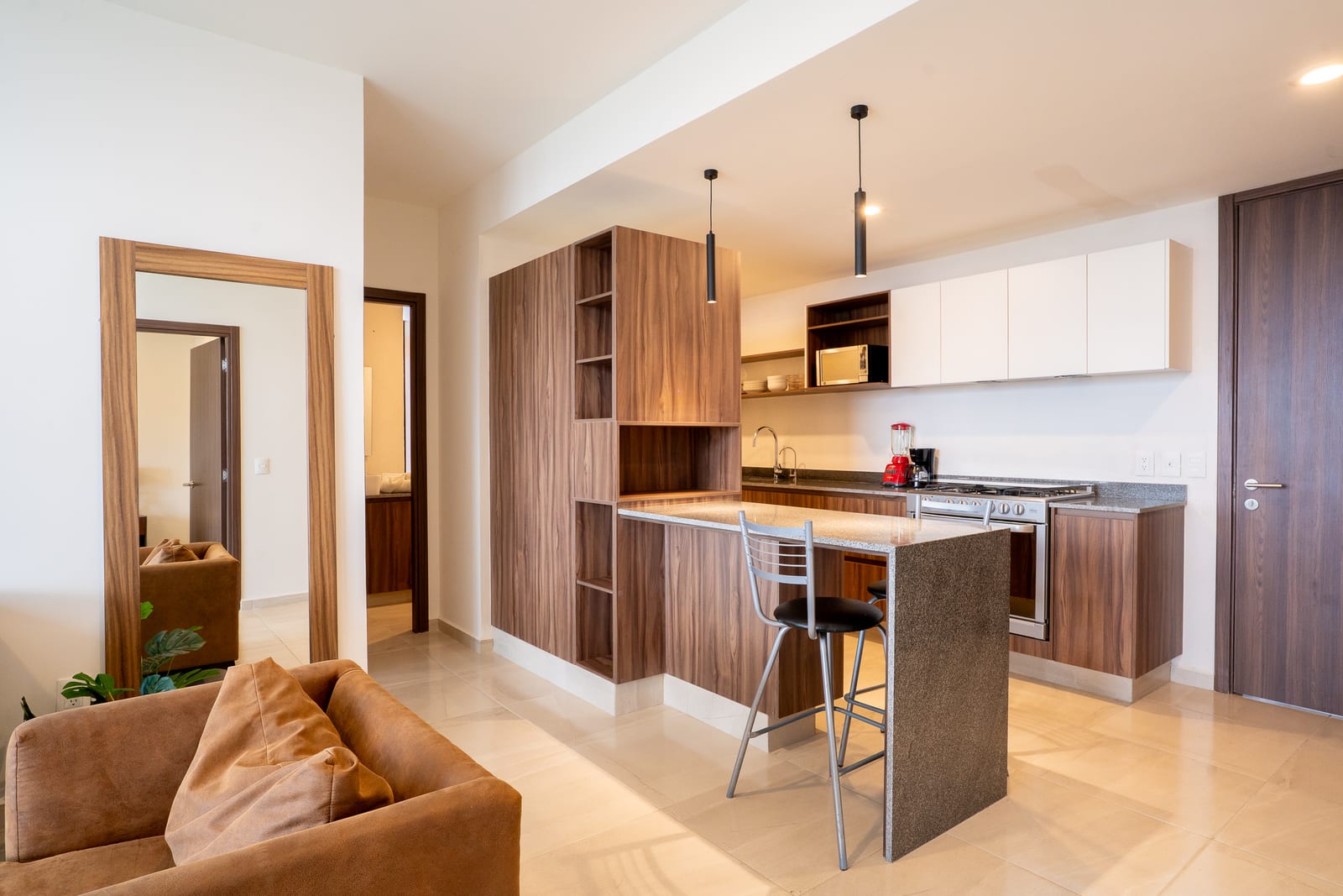 Cocina moderna con barra y taburetes altos.