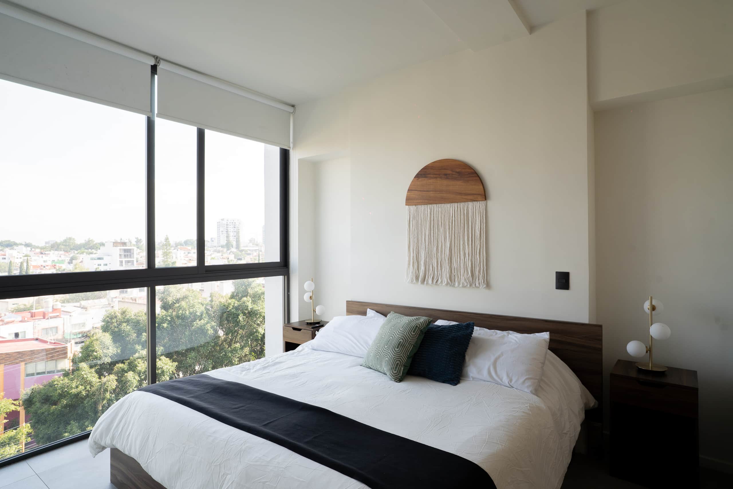 Recámara principal con cama matrimonial y gran ventana