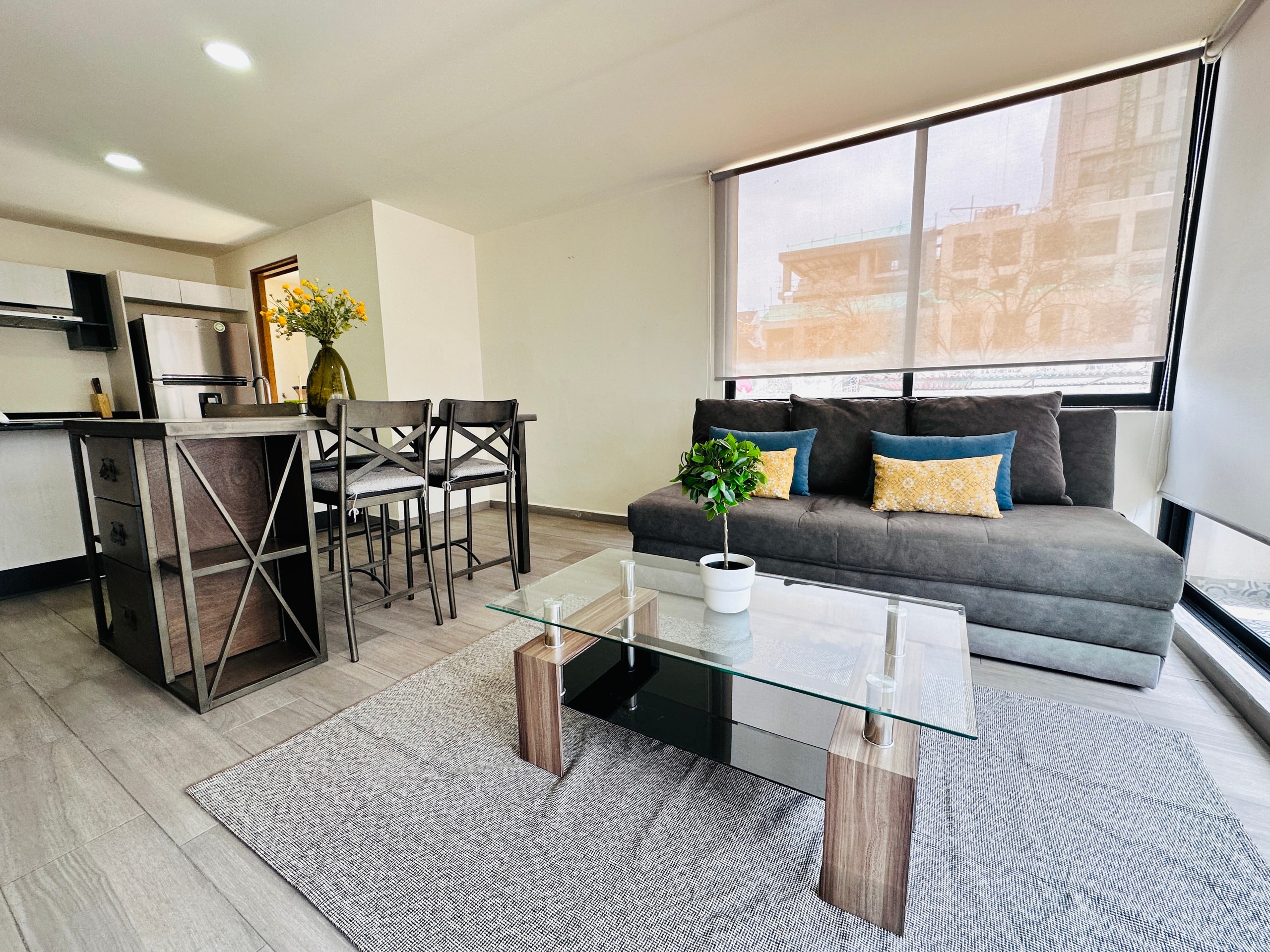 Sala, comedor y cocina integrados con ventanal.
