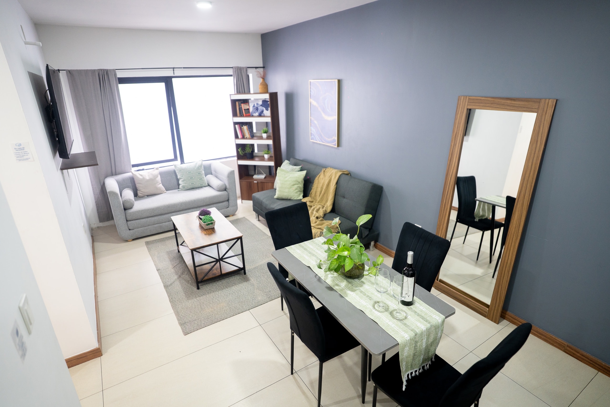 Sala comedor amplia con sofás, mesa, ventana.