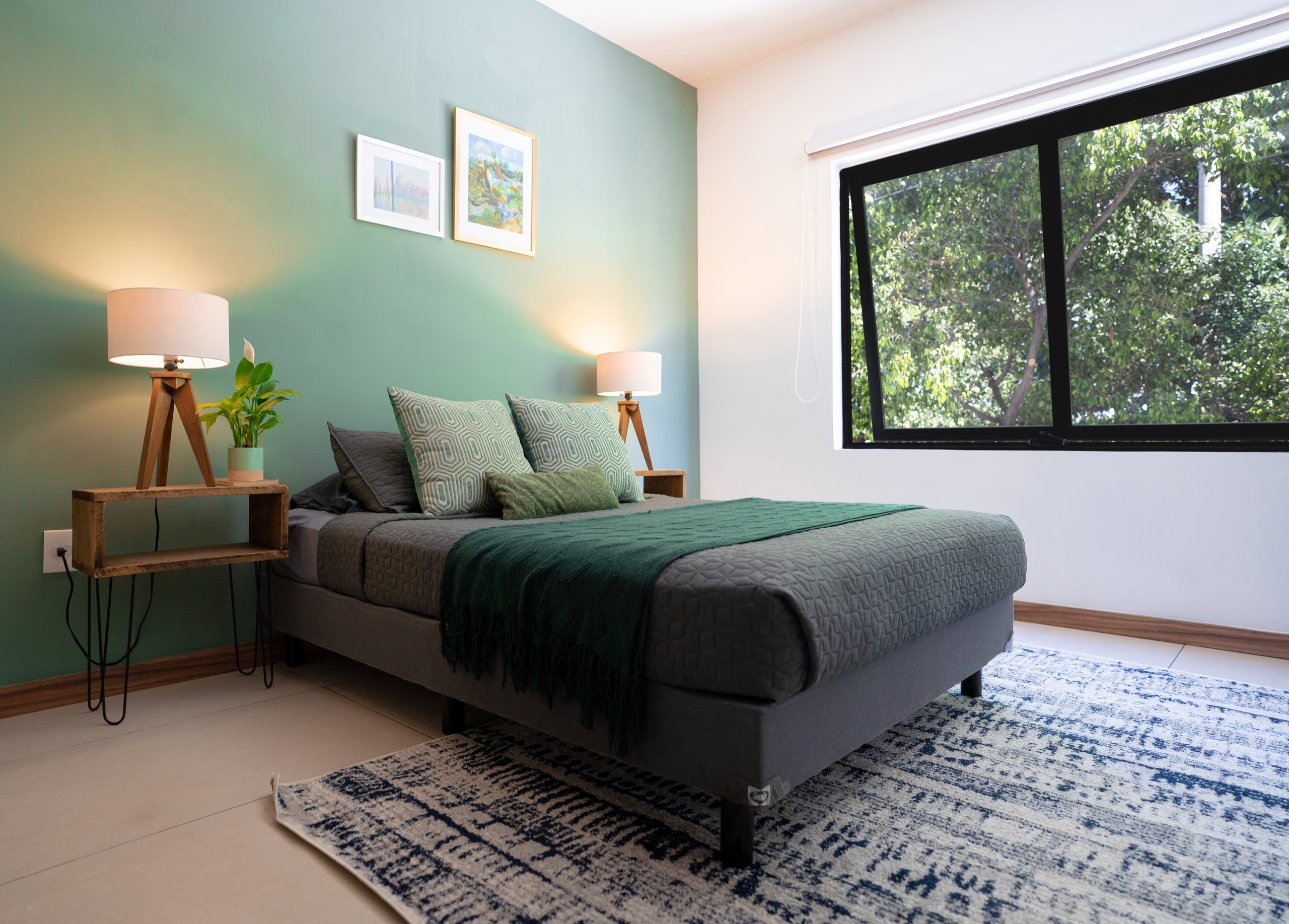 Recámara con cama matrimonial y pared verde